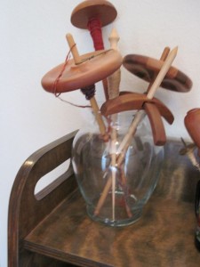 A large glass jar/vase holds larger/heavier spindles
