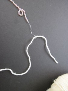 Pull project yarn/thread through knotted loop
